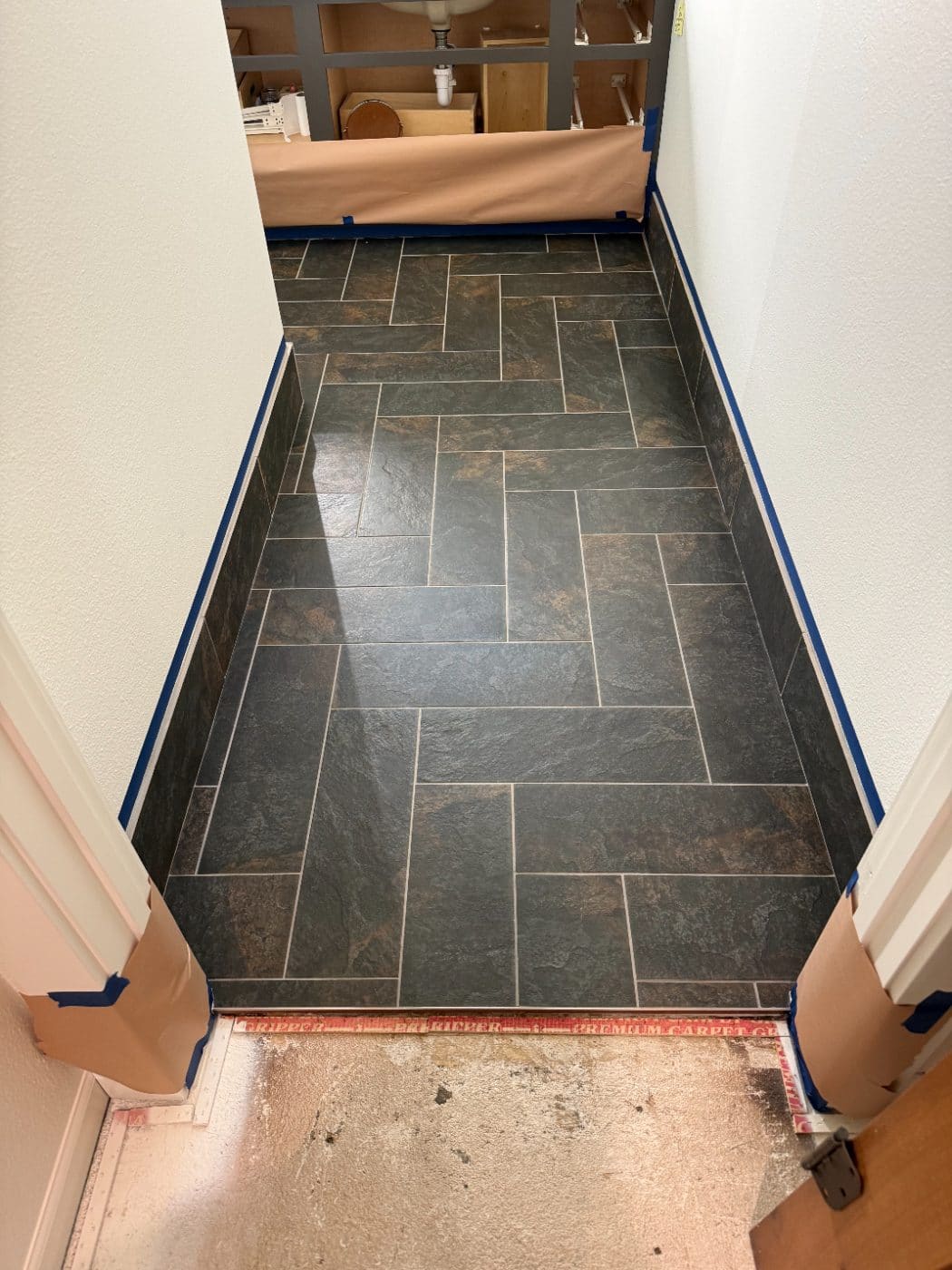 Herringbone tile floor before microcement installation